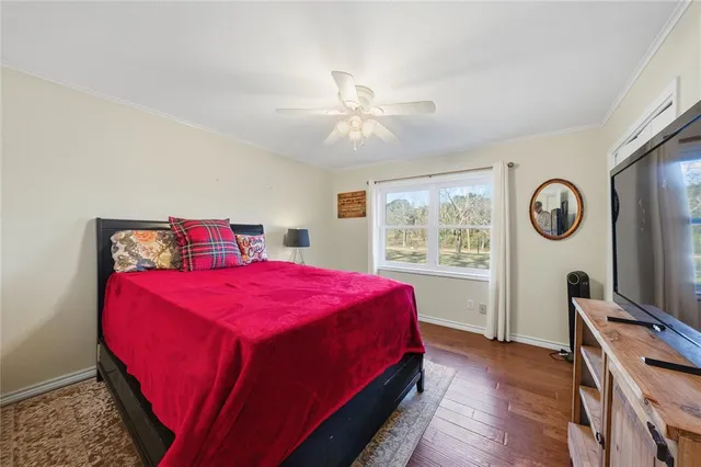a spacious bedroom with a bed and wooden floor