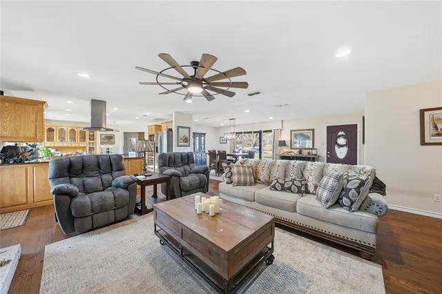 a living room with furniture kitchen view and a chandelier