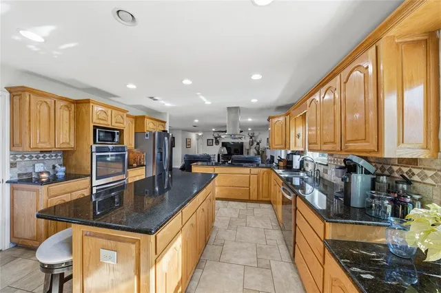 a kitchen with stainless steel appliances granite countertop sink stove top oven and cabinets
