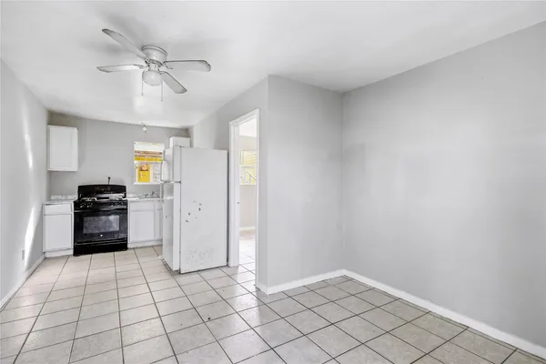 a view of an empty room and a kitchen