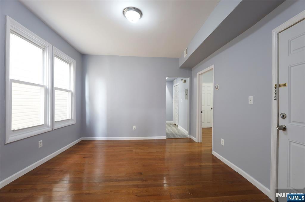 119 Ridgewood Avenue Newark, NJ 07108 - Photo 11 of 38 a view of an empty room with wooden floor and a window