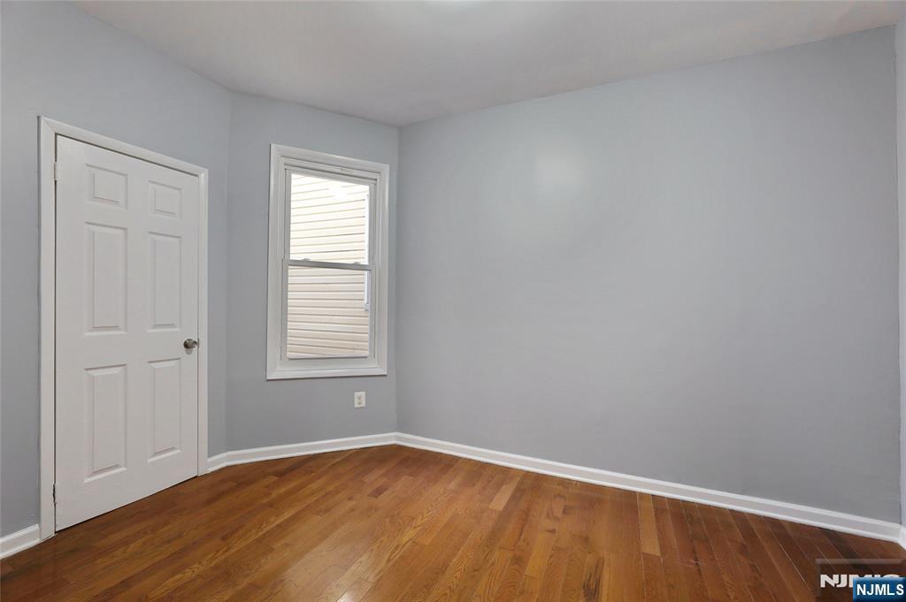 119 Ridgewood Avenue Newark, NJ 07108 - Photo 12 of 38 a view of an empty room with wooden floor and a window