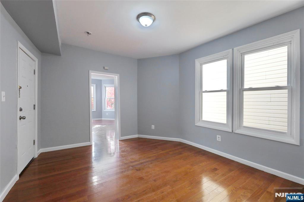 119 Ridgewood Avenue Newark, NJ 07108 - Photo 14 of 38 a view of an empty room with wooden floor and a window