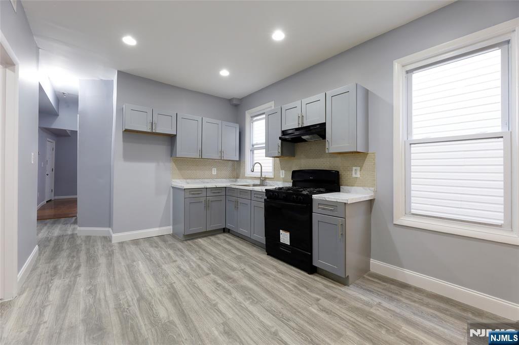 119 Ridgewood Avenue Newark, NJ 07108 - Photo 19 of 38 a kitchen with kitchen island granite countertop a sink cabinets and a window