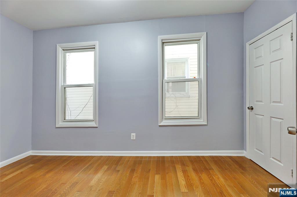 119 Ridgewood Avenue Newark, NJ 07108 - Photo 20 of 38 a view of an empty room with wooden floor and a window