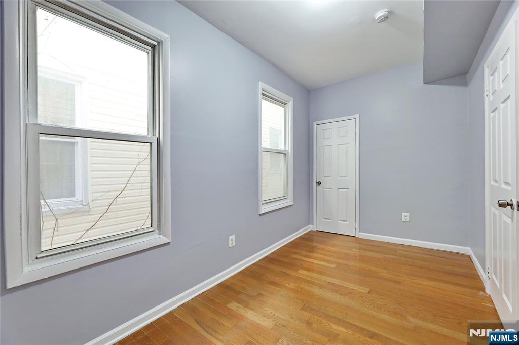 119 Ridgewood Avenue Newark, NJ 07108 - Photo 21 of 38 a view of an empty room with wooden floor and a window