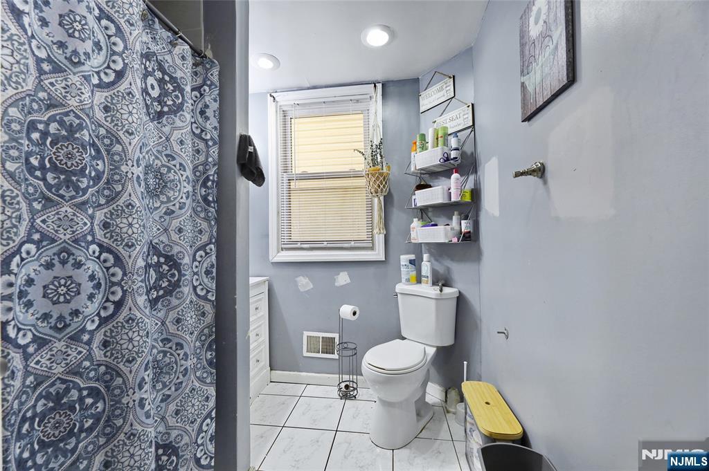 119 Ridgewood Avenue Newark, NJ 07108 - Photo 30 of 38 a bathroom with a toilet sink and mirror