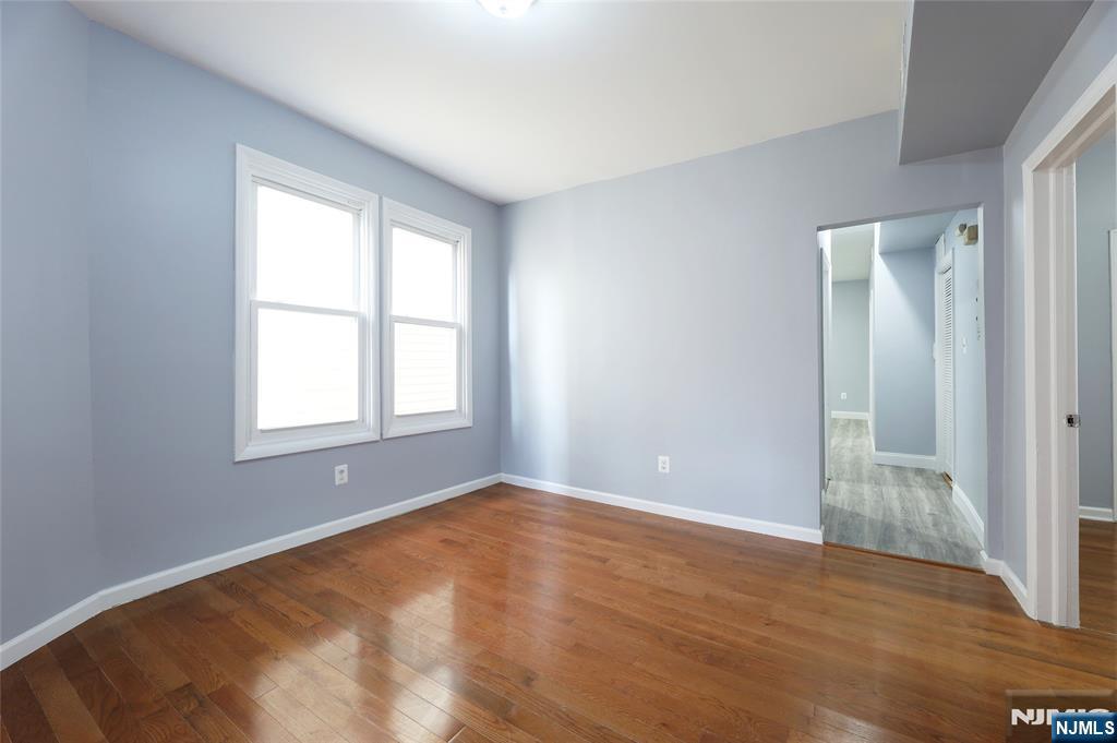 119 Ridgewood Avenue Newark, NJ 07108 - Photo 7 of 38 a view of an empty room with wooden floor and a window