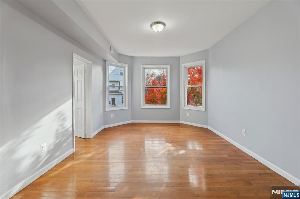 119 Ridgewood Avenue Newark, NJ 07108 - Photo 8 of 38 a view of an empty room with window and wooden floor