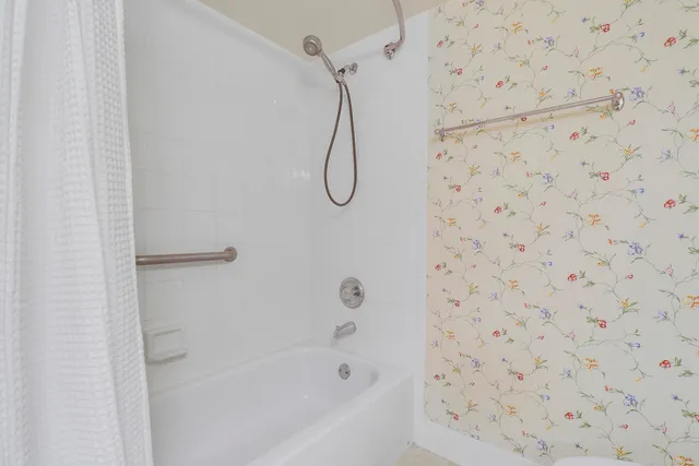 a bathroom with a bath tub with a shower