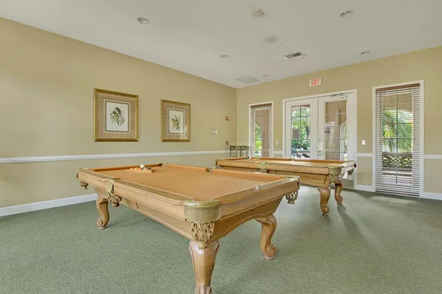 a room with pool table and windows
