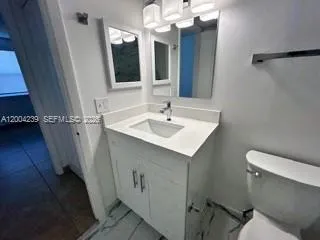 a bathroom with a sink toilet and mirror