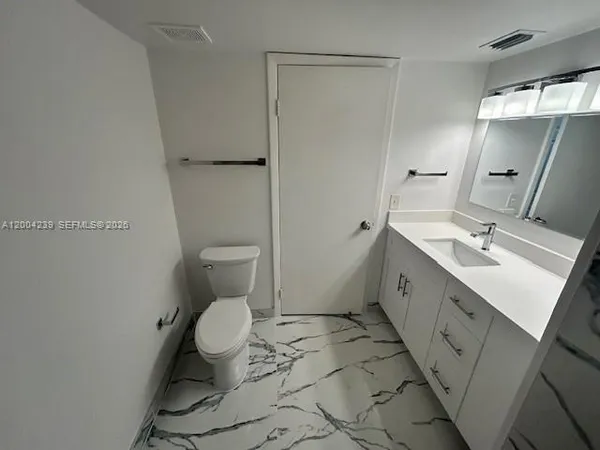 a bathroom with a sink mirror and toilet