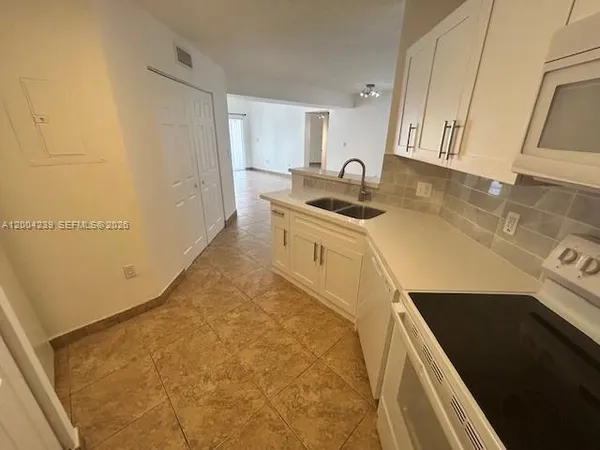 a kitchen with stainless steel appliances a sink stove and cabinets