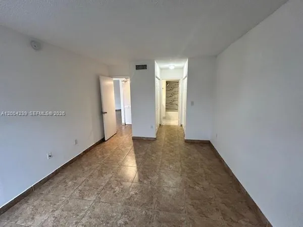 an empty room with closet and wooden door