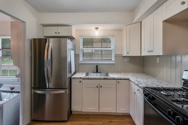 a kitchen with a refrigerator sink and cabinets