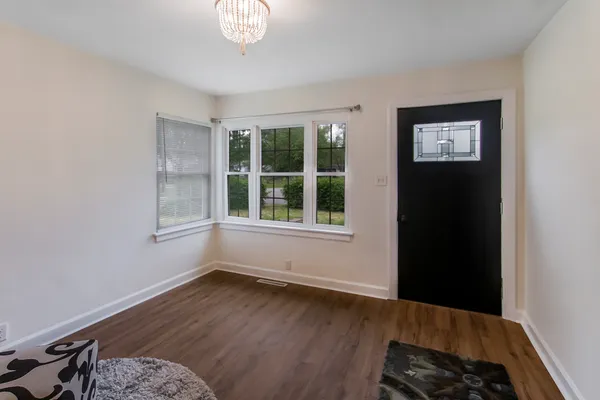 a view of a big room with wooden floor and windows