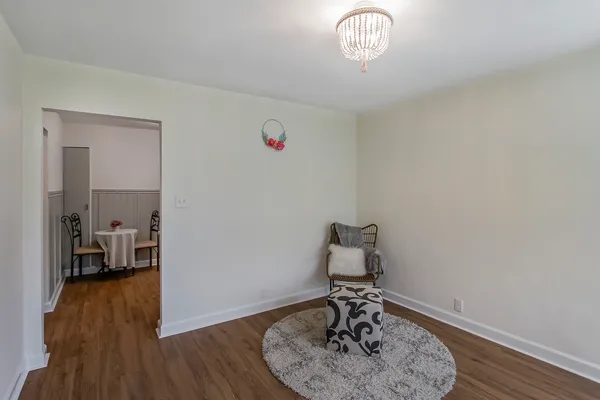a view of a livingroom with wooden floor and a chandelier