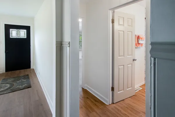 a view of a hallway with wooden floor and entryway