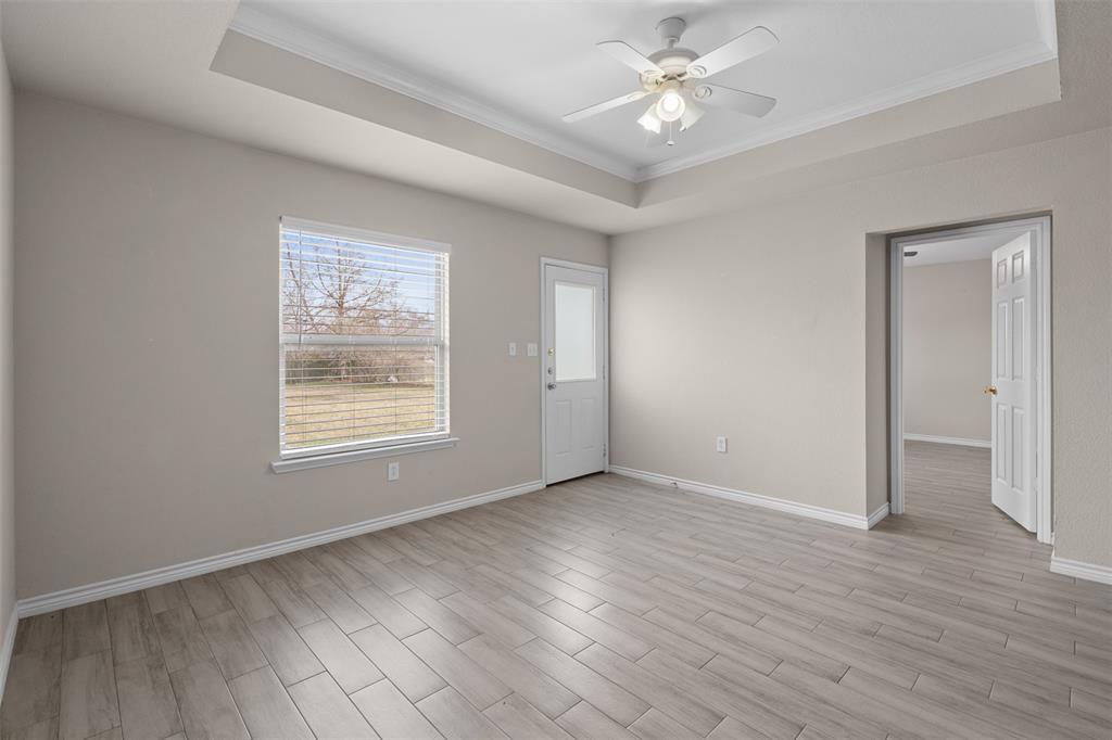 503 Caddell Street Aubrey, TX 76227 - Photo 11 of 39 a view of an empty room with wooden floor and a window