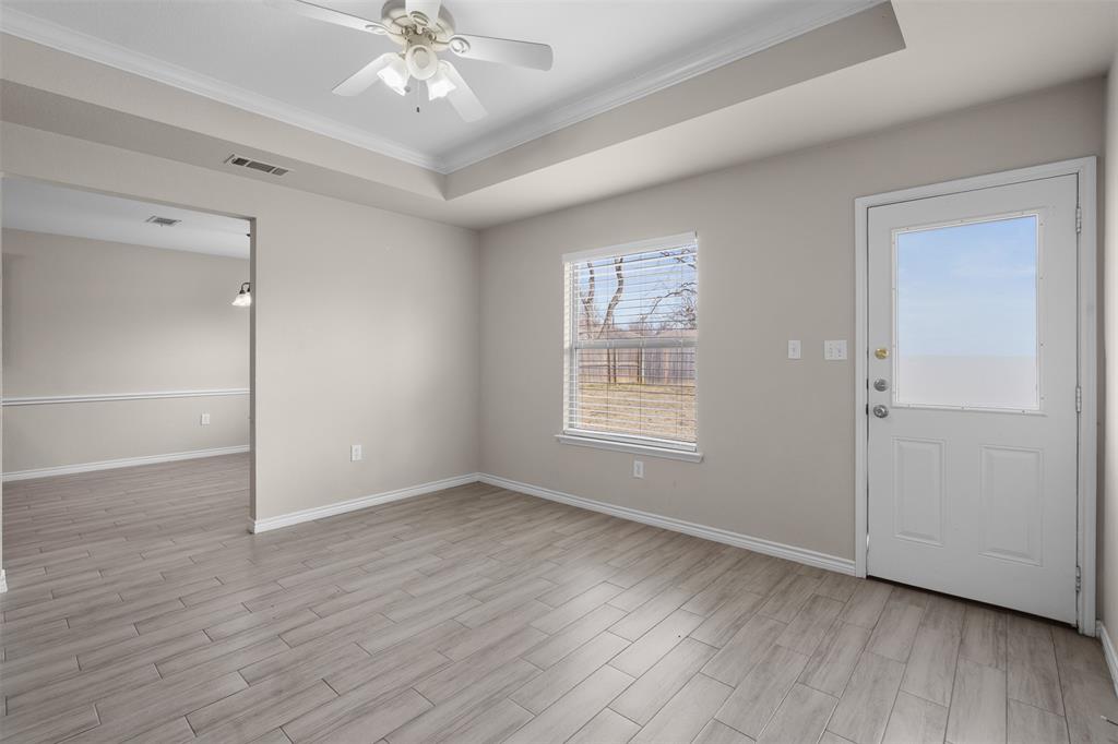 503 Caddell Street Aubrey, TX 76227 - Photo 12 of 39 an empty room with wooden floor chandelier fan and windows