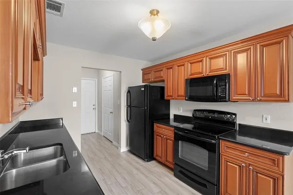 a kitchen with stainless steel appliances granite countertop a refrigerator stove top oven and sink