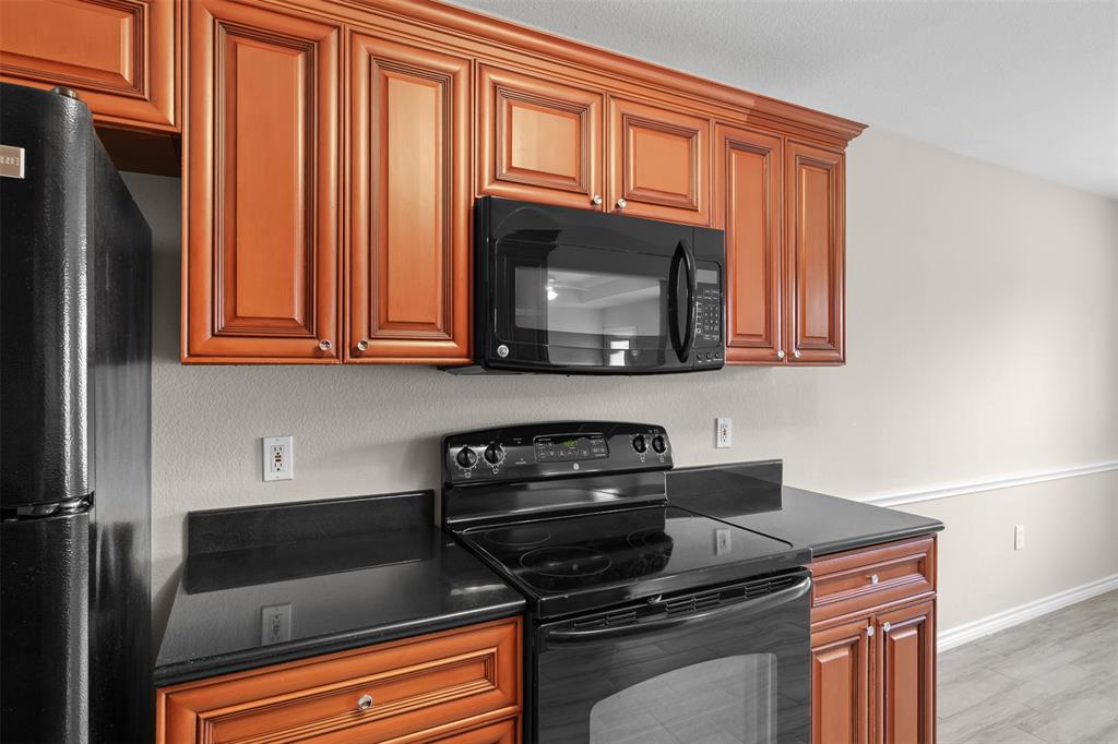 503 Caddell Street Aubrey, TX 76227 - Photo 17 of 39 a kitchen with wooden cabinets and a stove top oven