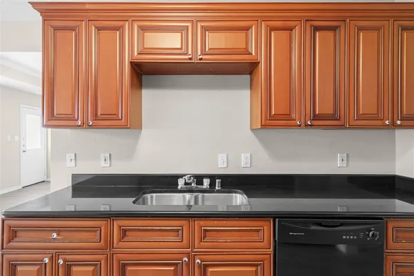 a kitchen with granite countertop a sink a stove and cabinets