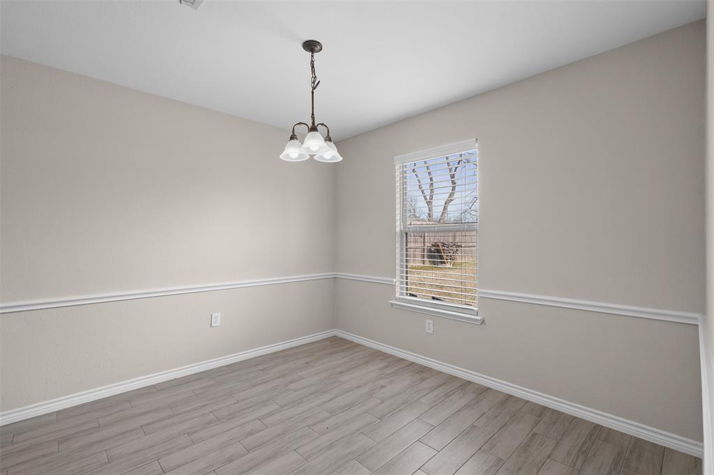 503 Caddell Street Aubrey, TX 76227 - Photo 20 of 39 a view of an empty room with a window and wooden floor