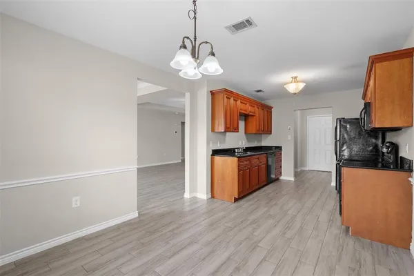 a kitchen with stainless steel appliances granite countertop wooden floors and a sink