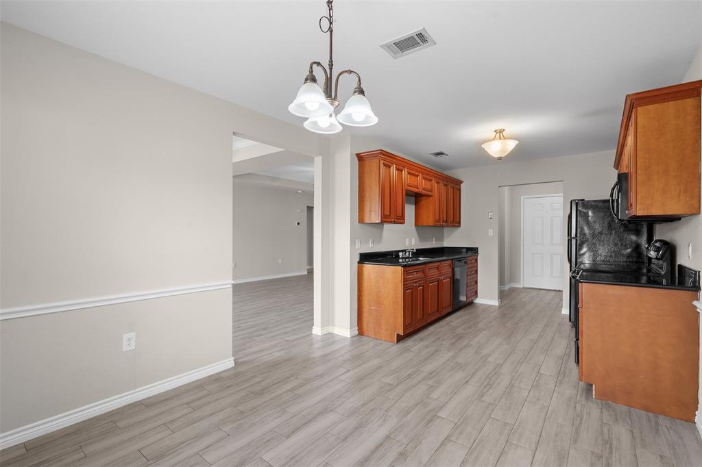 503 Caddell Street Aubrey, TX 76227 - Photo 21 of 39 a kitchen with stainless steel appliances granite countertop wooden floors and a sink