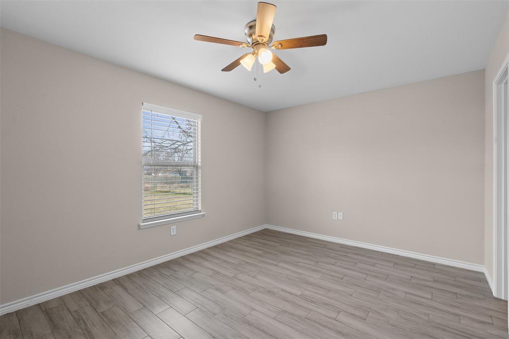 503 Caddell Street Aubrey, TX 76227 - Photo 22 of 39 an empty room with wooden floor and windows