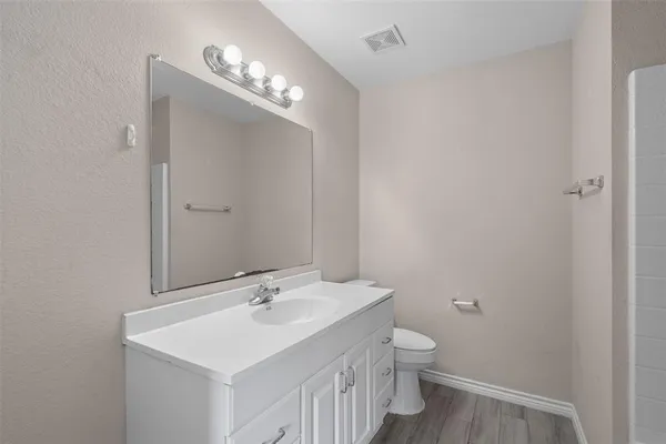 a bathroom with a toilet a sink and mirror