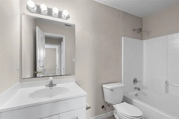a bathroom with a sink vanity mirror and toilet