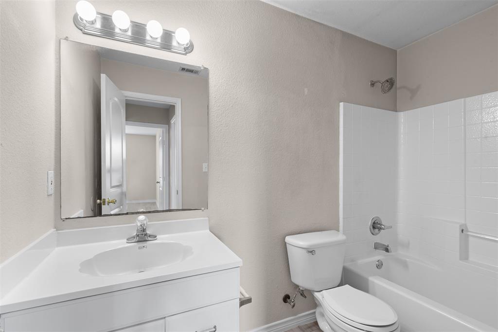 503 Caddell Street Aubrey, TX 76227 - Photo 31 of 39 a bathroom with a sink vanity mirror and toilet