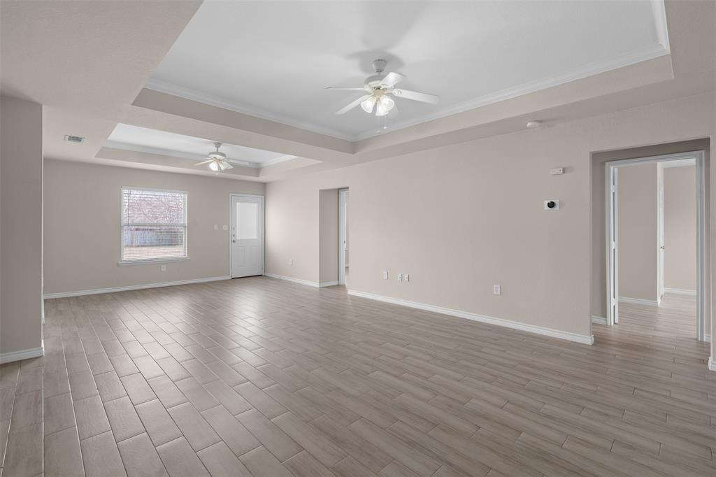 503 Caddell Street Aubrey, TX 76227 - Photo 7 of 39 a view of an empty room with wooden floor and a window