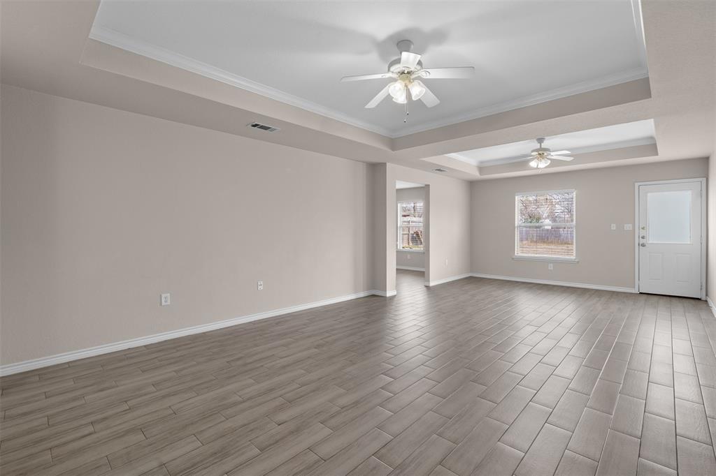 503 Caddell Street Aubrey, TX 76227 - Photo 8 of 39 a view of an empty room with a window and wooden floor