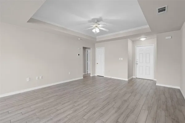 a view of an empty room with wooden floor
