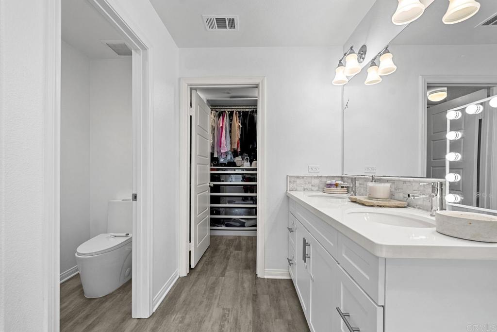 8614 Skylight Way El Cajon, CA 92021 - Photo 20 of 65 a spacious bathroom with a double vanity sink a toilet and a mirror