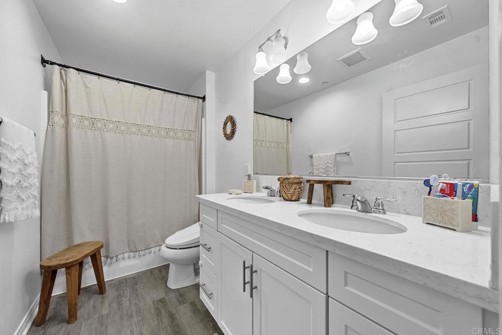 8614 Skylight Way El Cajon, CA 92021 - Photo 28 of 65 a bathroom with a sink a toilet and a mirror