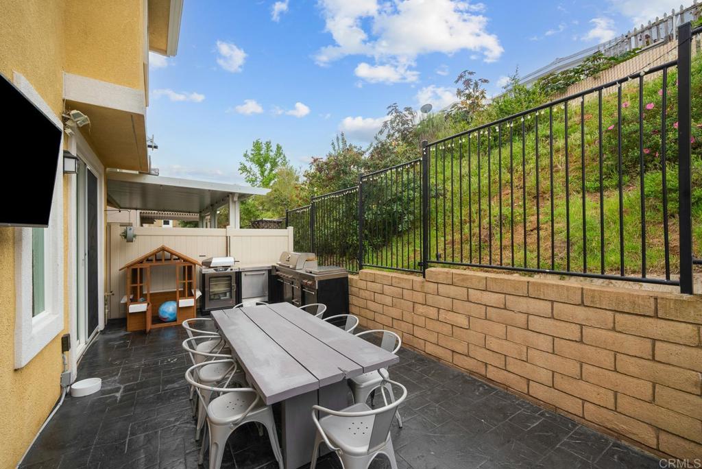 8614 Skylight Way El Cajon, CA 92021 - Photo 41 of 65 a view of a patio with table and chairs with wooden floor and fence