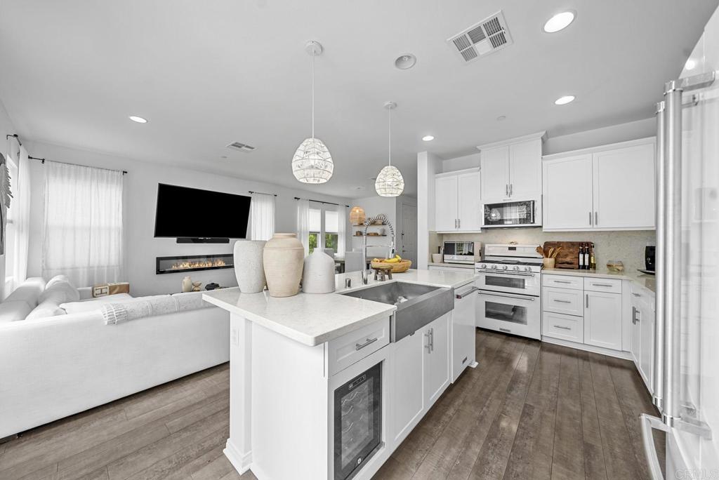 8614 Skylight Way El Cajon, CA 92021 - Photo 6 of 65 a large white kitchen with cabinets a sink and a stove top oven