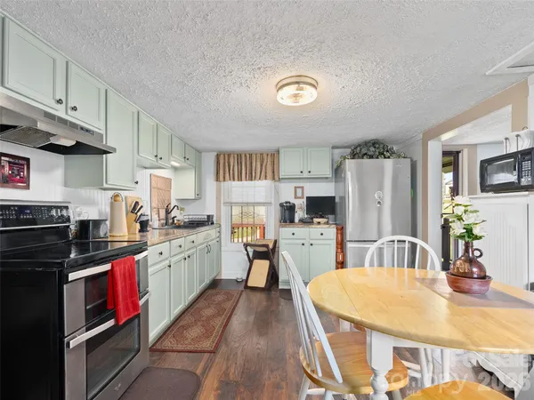 a kitchen with stainless steel appliances granite countertop a stove refrigerator and cabinets