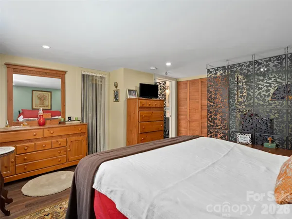 a bedroom with a large bed and a dresser