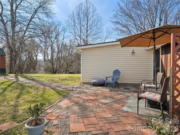 a view of a chair and table in backyard of the house