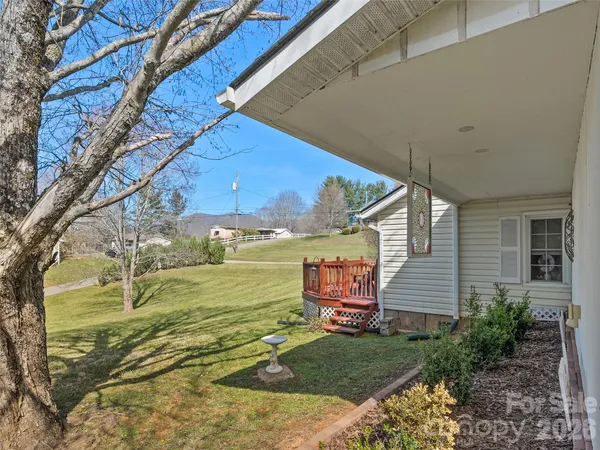 a view of a backyard with lawn chairs and iron fence