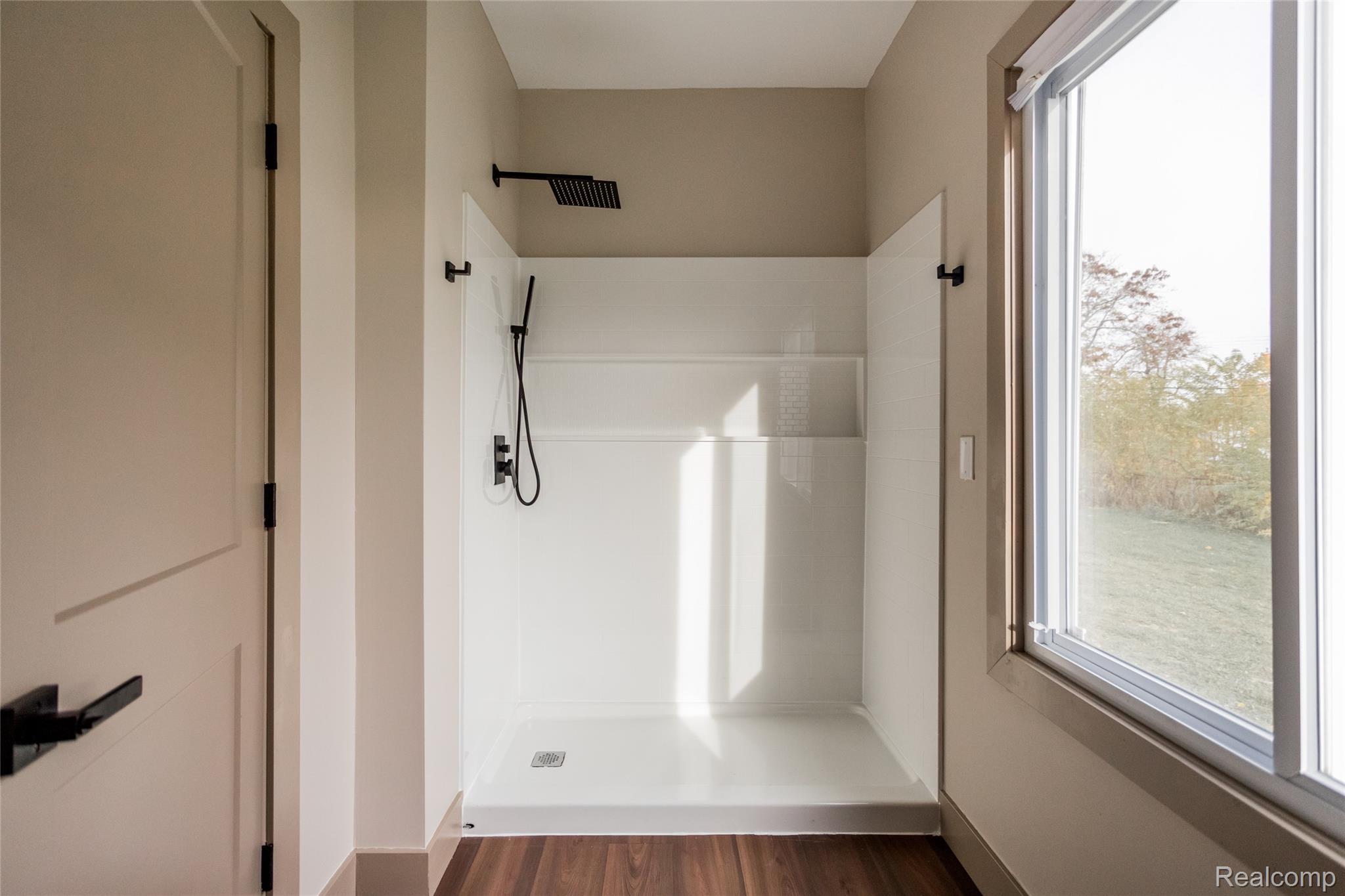 2630 Harding Street Detroit, MI 48214 - Photo 16 of 30 Shower stall with matte black fixtures, integrated shelving, and a rain shower head