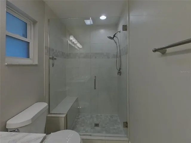 a bathroom with a toilet and a shower