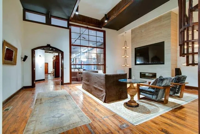 a living room with furniture a flat screen tv and kitchen view