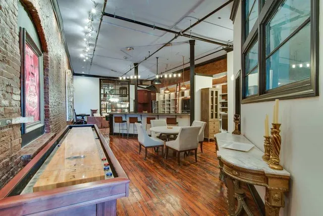 a dining room with wooden floor and large windows